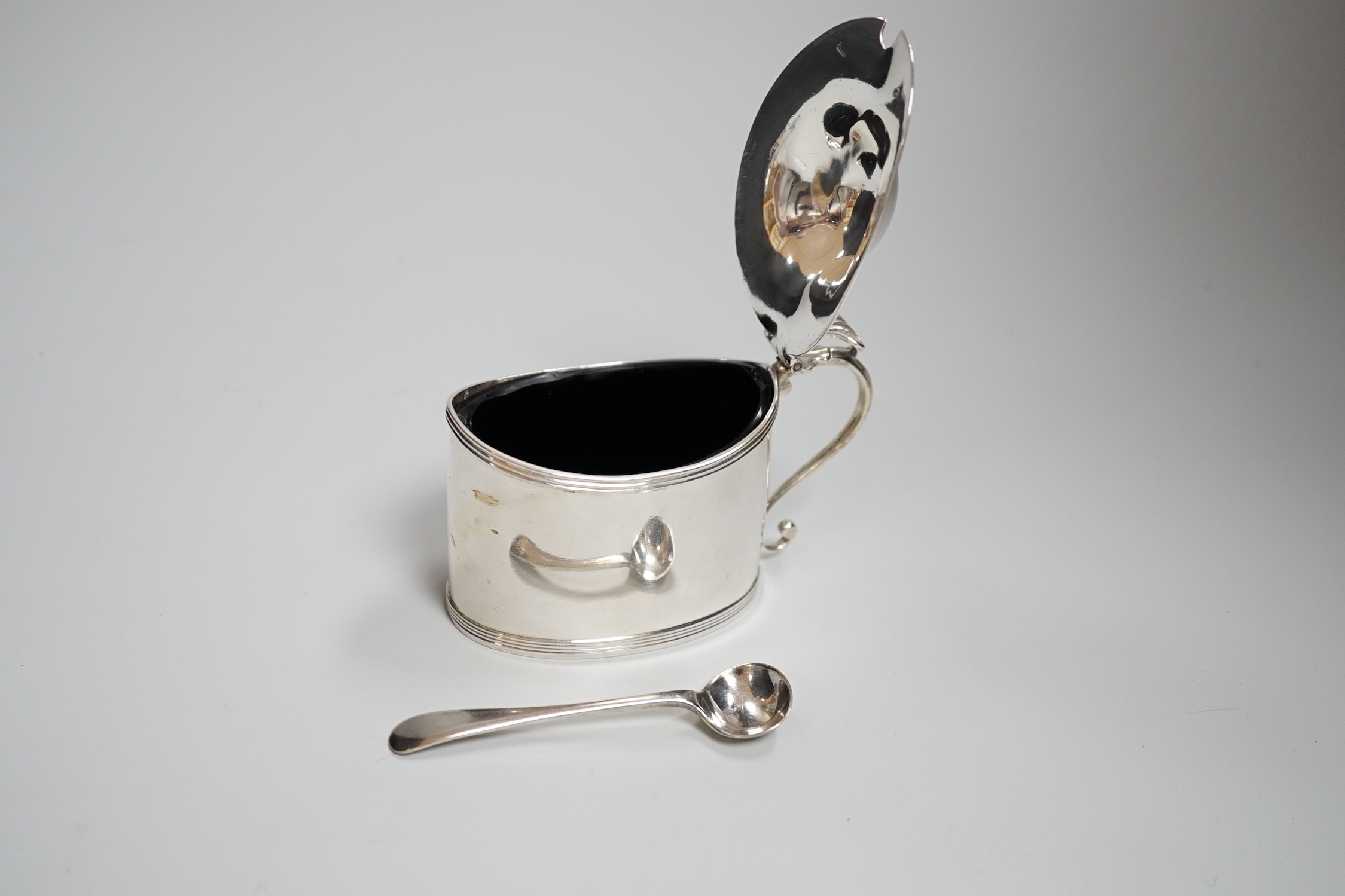 A George III oval silver drum mustard, with domed cover, glass liner and plated spoon, makers Peter, Anne and William Bateman, London 1800, 121 grams